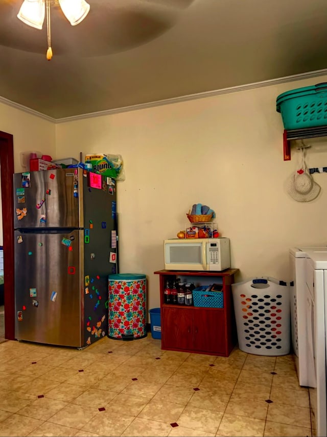 kitchen featuring washer / clothes dryer, stainless steel refrigerator, and crown molding