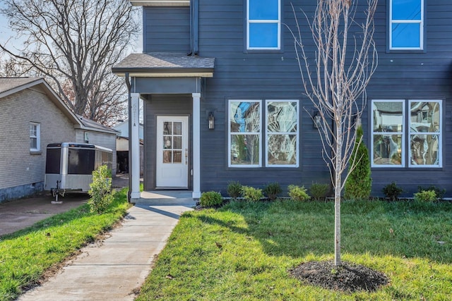 view of exterior entry with a yard