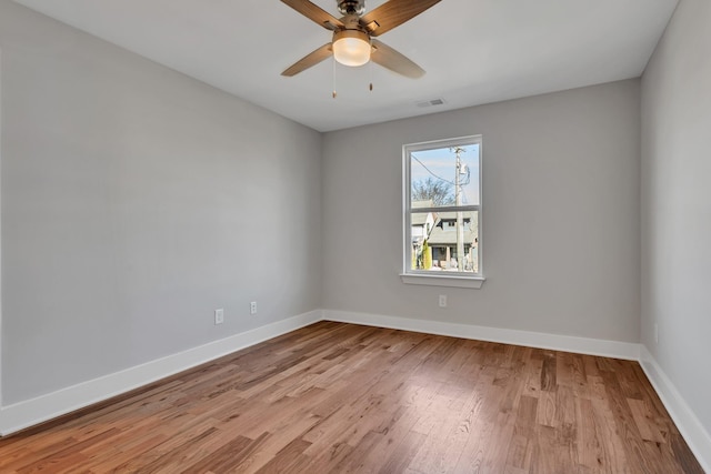 empty room with ceiling fan and light hardwood / wood-style floors