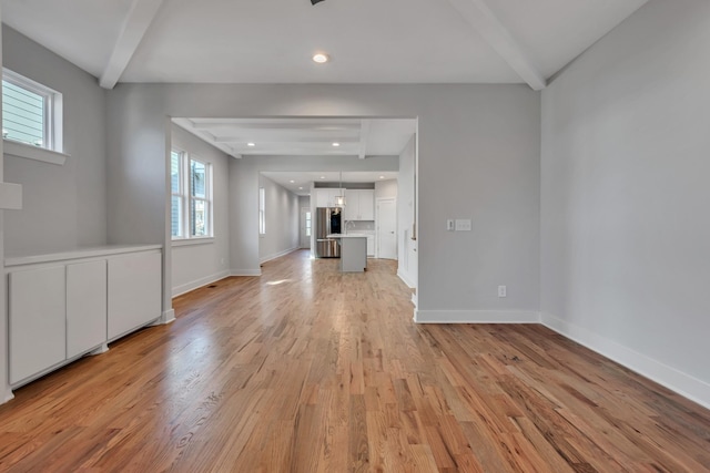 unfurnished living room featuring light hardwood / wood-style flooring and beam ceiling