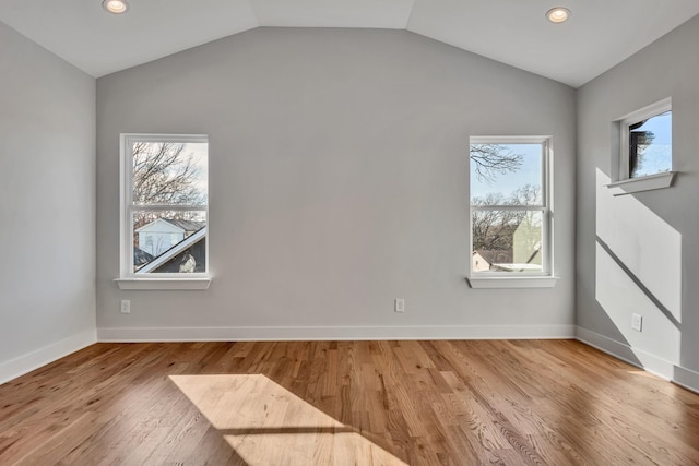 empty room with light hardwood / wood-style flooring and vaulted ceiling