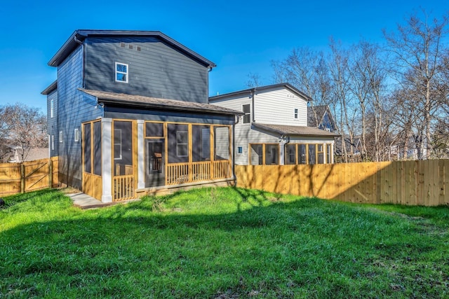 rear view of house featuring a lawn and a sunroom