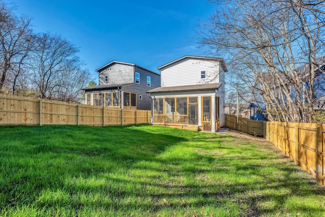 back of house with a sunroom and a lawn