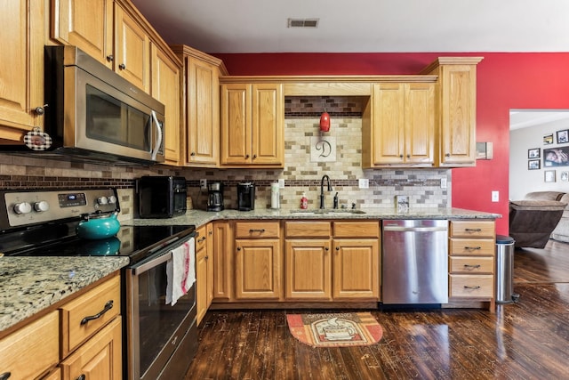 kitchen featuring dark wood-type flooring, sink, appliances with stainless steel finishes, and tasteful backsplash