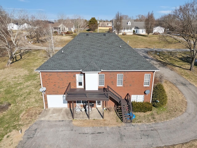 rear view of house with a yard and a garage