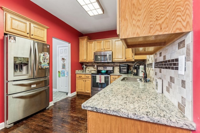 kitchen featuring stainless steel appliances, decorative backsplash, light brown cabinets, and sink