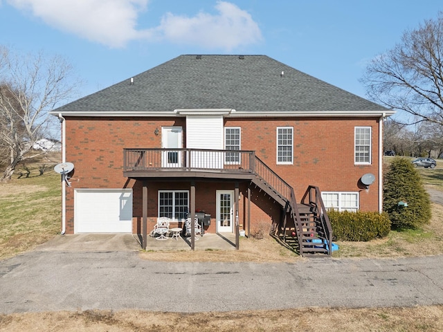 rear view of house featuring a garage, a patio area, and a wooden deck