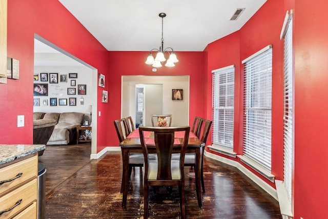 dining area with a chandelier and dark hardwood / wood-style flooring