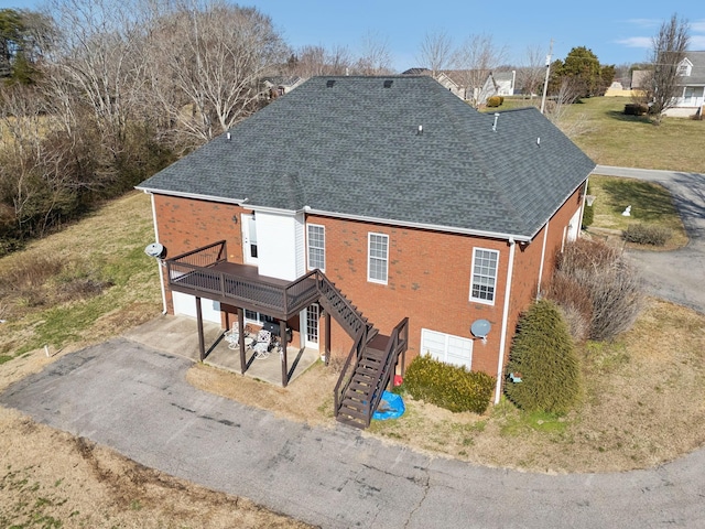 exterior space featuring a deck, a garage, and a patio