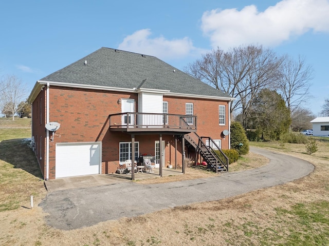 rear view of property featuring a garage and a wooden deck