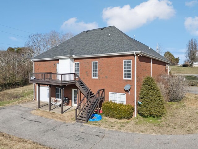 back of house with a garage and a wooden deck