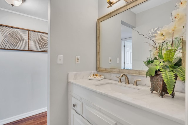 bathroom with ornamental molding, hardwood / wood-style floors, and vanity