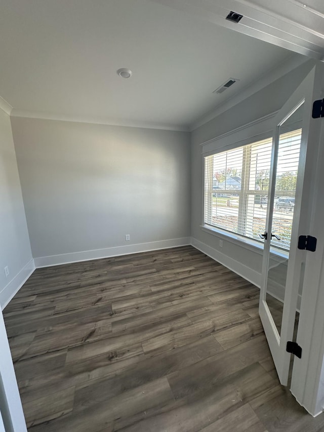 empty room featuring dark hardwood / wood-style flooring and crown molding