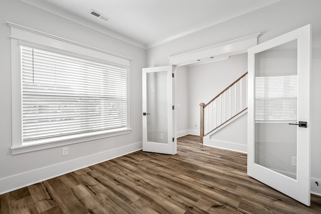 empty room with dark hardwood / wood-style flooring, crown molding, and french doors