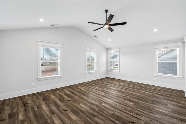 spare room with lofted ceiling, dark wood-type flooring, a wealth of natural light, and ceiling fan