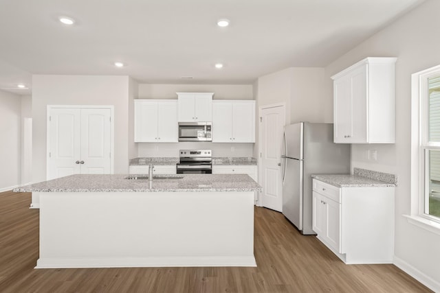 kitchen featuring appliances with stainless steel finishes, sink, white cabinetry, and a center island with sink