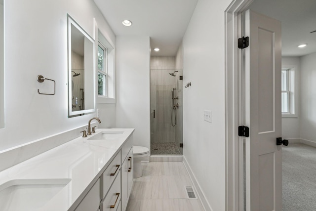 bathroom featuring a shower with shower door, toilet, and vanity