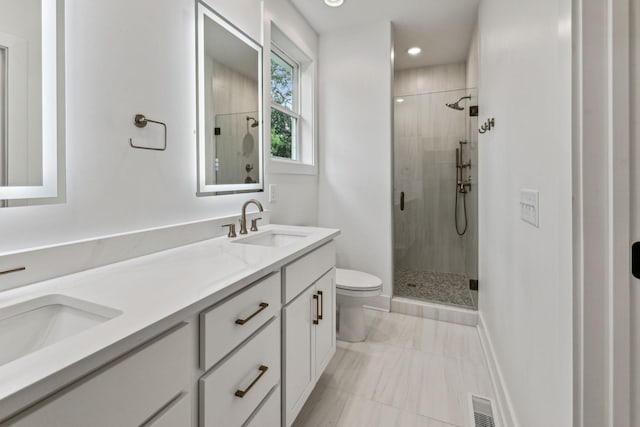 bathroom with a shower with shower door, vanity, and toilet