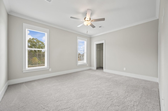 spare room featuring ceiling fan, crown molding, and plenty of natural light