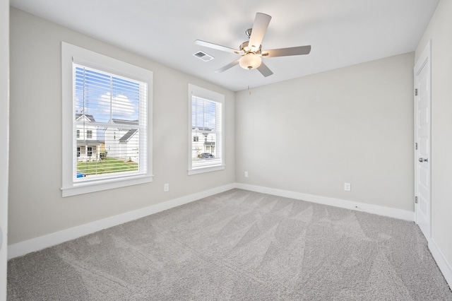 carpeted spare room featuring ceiling fan