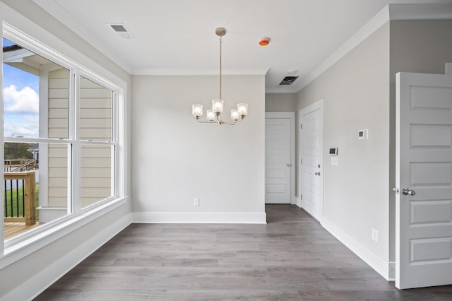 unfurnished dining area with a chandelier, ornamental molding, and hardwood / wood-style floors