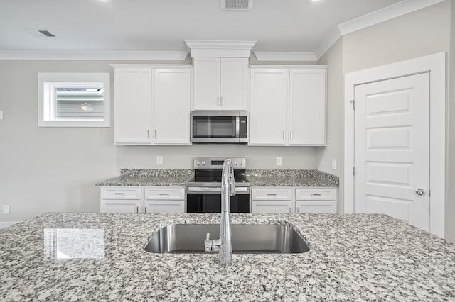 kitchen featuring sink, crown molding, white cabinetry, appliances with stainless steel finishes, and light stone counters