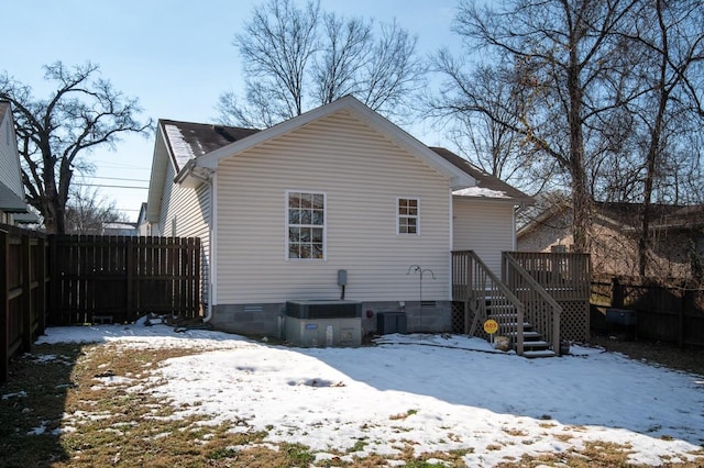 snow covered house featuring a wooden deck