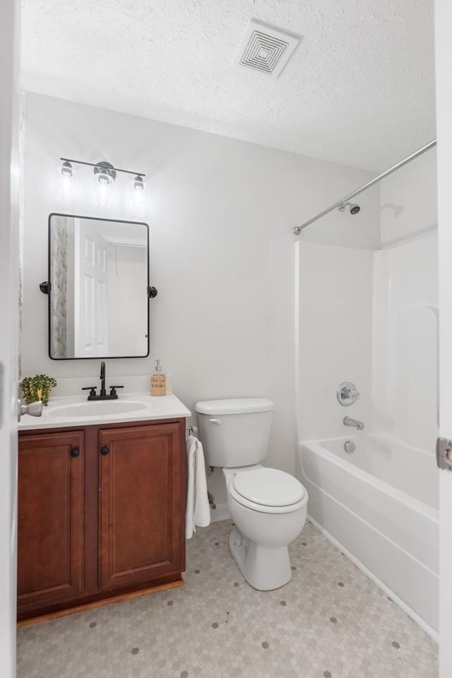 full bathroom with toilet, a textured ceiling,  shower combination, and vanity