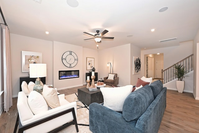 living room featuring ceiling fan and light hardwood / wood-style flooring