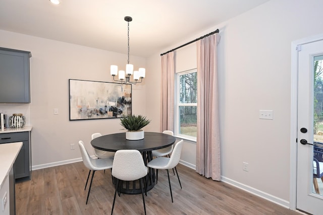 dining room with light hardwood / wood-style floors and a notable chandelier