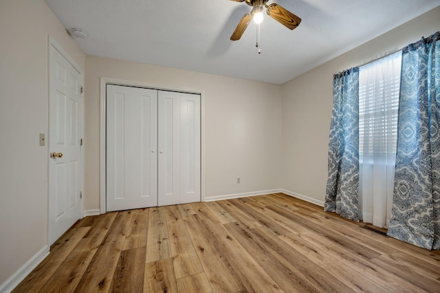 unfurnished bedroom with ceiling fan, a closet, and light hardwood / wood-style floors