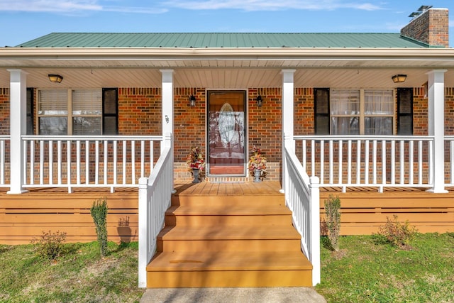 view of exterior entry featuring covered porch