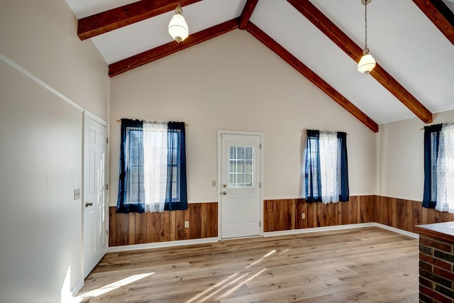 entryway with a healthy amount of sunlight, wood-type flooring, and high vaulted ceiling