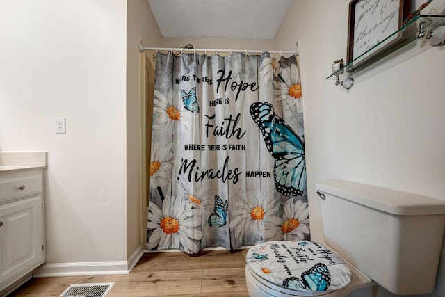 bathroom featuring a textured ceiling, vanity, toilet, a shower with shower curtain, and hardwood / wood-style flooring