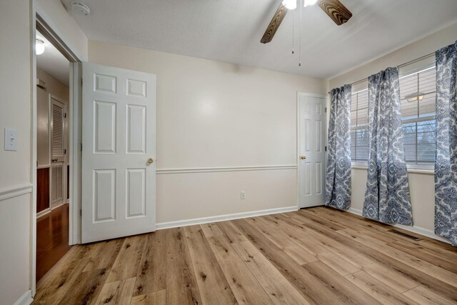 unfurnished bedroom with ceiling fan and light hardwood / wood-style flooring