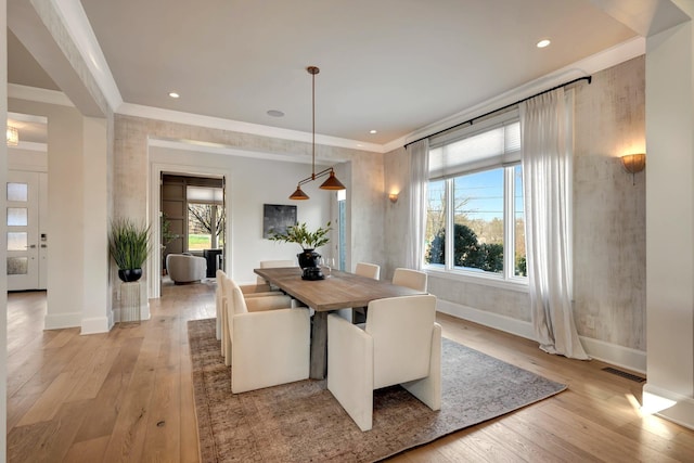 dining area featuring crown molding and light hardwood / wood-style flooring