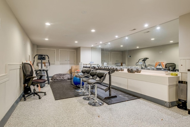 exercise room featuring light carpet