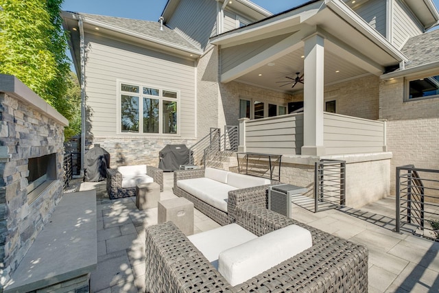 view of patio with ceiling fan, a grill, and an outdoor living space with a fireplace