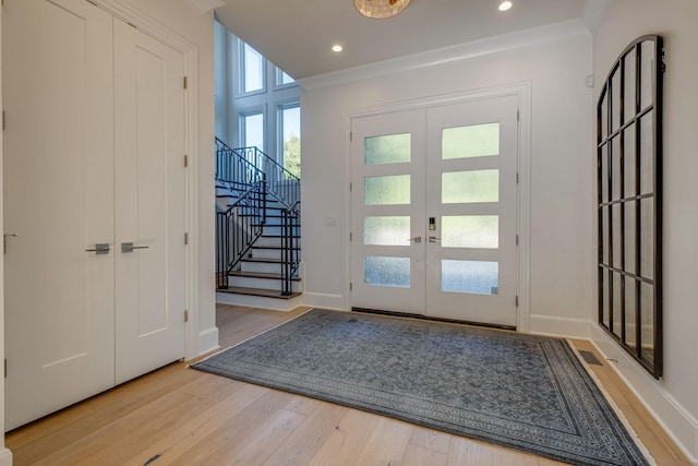 interior space featuring french doors, ornamental molding, and light hardwood / wood-style floors