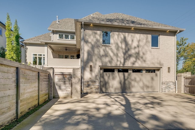 rear view of house featuring ceiling fan and a garage