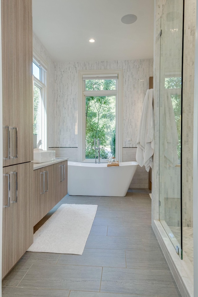 bathroom with tile patterned flooring, shower with separate bathtub, plenty of natural light, and vanity