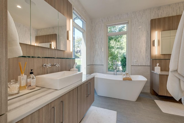 bathroom featuring vanity, tile patterned flooring, plenty of natural light, and a bath