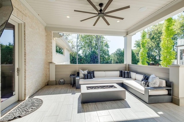 view of patio / terrace featuring ceiling fan and an outdoor living space with a fire pit