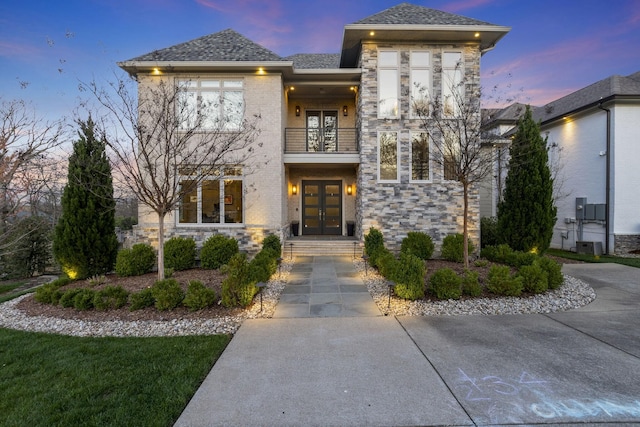 view of front facade featuring central AC, french doors, and a balcony