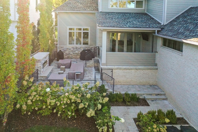 property entrance featuring an outdoor living space with a fireplace and a patio