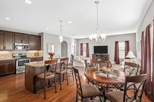 dining space with an inviting chandelier and dark hardwood / wood-style floors