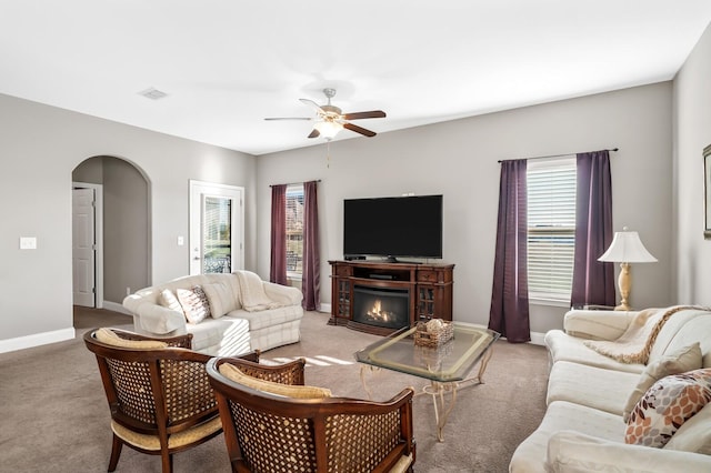 carpeted living room with ceiling fan