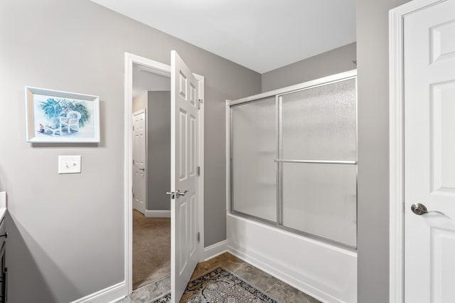 bathroom with combined bath / shower with glass door, vanity, and tile patterned flooring