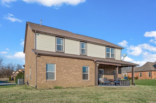 back of property with a lawn and a patio