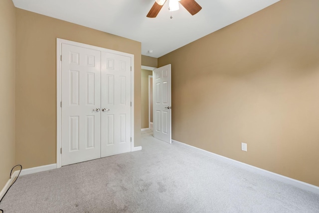 unfurnished bedroom with ceiling fan, a closet, and light colored carpet